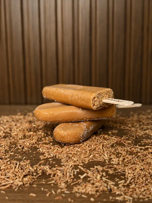 Picolés de coco queimado sobre coco tostado
